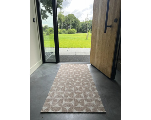 Fußmatte mit geometrischem Muster vor einer offenen Haustür