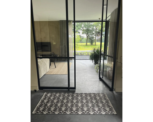 Innenraum mit gemustertem Teppich vor einer offenen Glastür