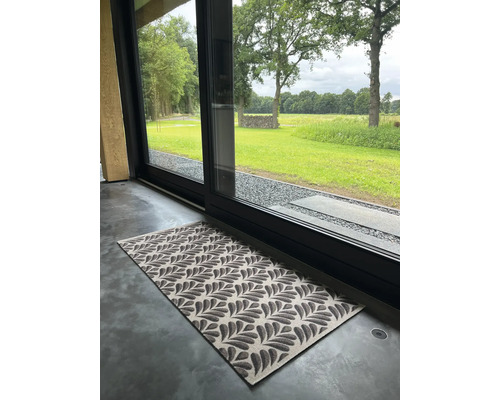 Fußmatte mit Blattmuster vor einer Schiebetür