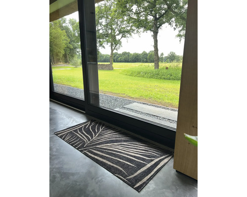 Fußmatte mit Blattmuster vor einer Terrassentür