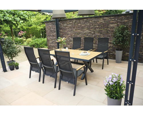 Gartenszene mit Esstisch und Stühlen auf einer Terrasse.