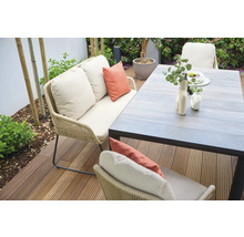 Gartenszene mit Sofa, Kissen und Esstisch auf einer Terrasse