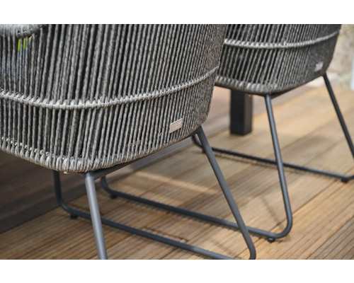 Detailansicht von zwei Rattan-Gartenstühlen mit Metallbeinen