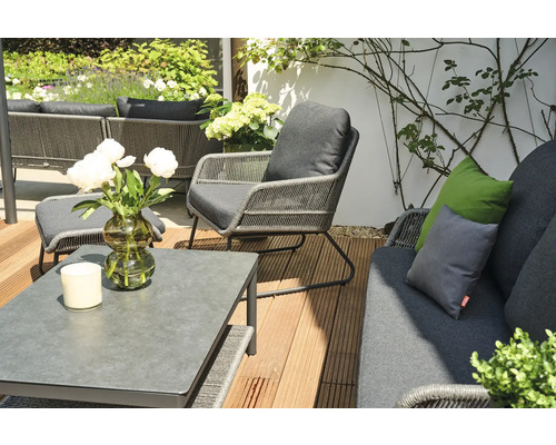 Terrassenszene mit Tisch, Stuhl und Sofa mit grauen Polstern und Kissen