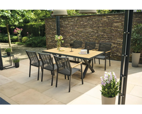 Gartenszene mit Esstisch, Stühlen und Gartendekoration auf einer Terrasse