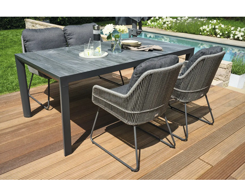 Gartentisch mit Stühlen auf einer Holzterrasse nahe einem Pool