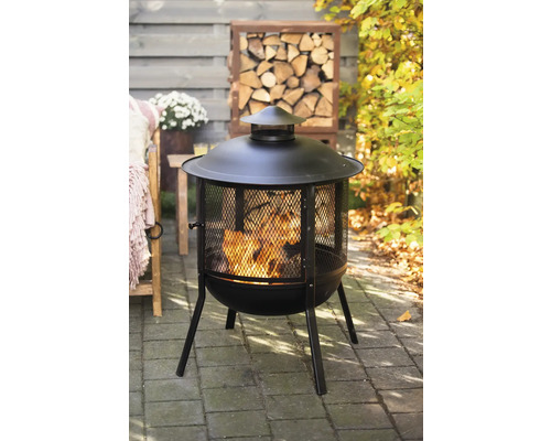 Feuerstelle mit Funkenschutzgitter und Holzscheitlager im Garten