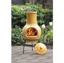 Mexikanischer Ofen mit Feuerstelle, aus Ton gefertigt und mit einem Deckel auf Pflastersteinen im Garten platziert.