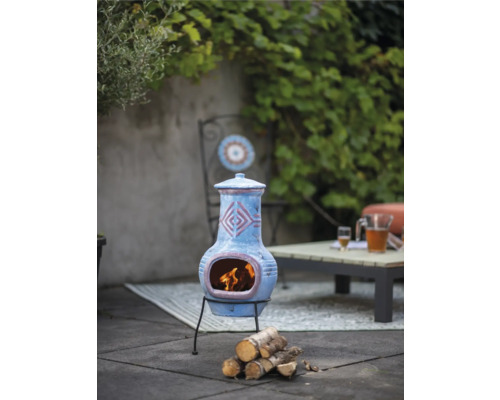 Dekorativer Terrakotta-Kaminofen mit Holz auf einer Terrasse