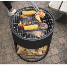 "Ein Holzkohlegrill mit Grillgut wie Hähnchen, Maiskolben und Fleischspießen wird mit einer Grillzange gewendet