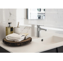 Helles Badezimmer mit Waschtisch, Armatur und Badaccessoires
