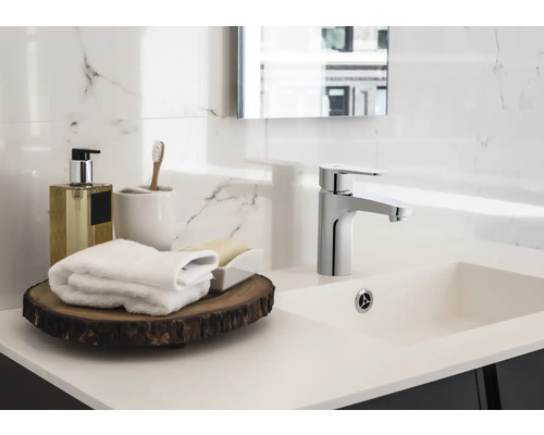 Helles Badezimmer mit Waschtisch, Armatur und Badaccessoires