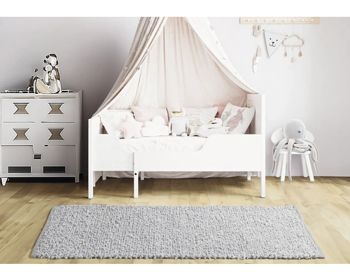 Kinderzimmer mit Bett, Kommode und Teppich