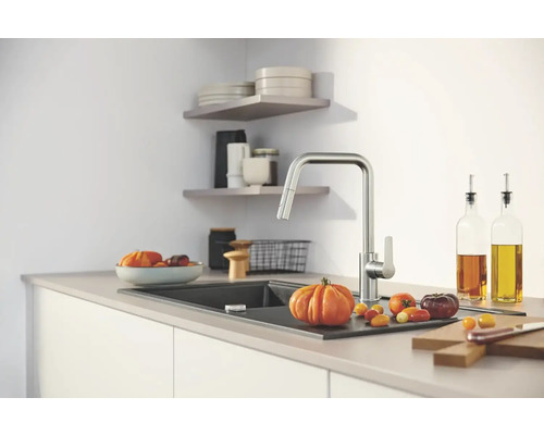 Küchenszene mit Spültischarmatur, Spülbecken und Lebensmitteln auf einer Arbeitsplatte.