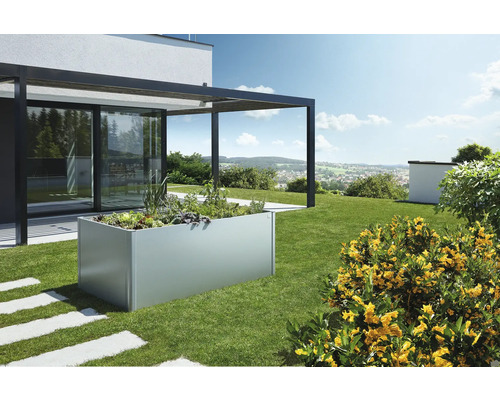 Hochbeet aus Metall im Garten mit Pflanzen und angrenzender Terrasse