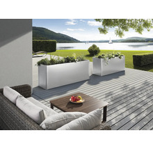 Dekorativer Gartenbereich mit Pflanzkästen, Sitzgruppe und Seeblick