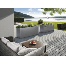 Terrasse mit Pflanzkästen und Sitzgruppe vor Seelandschaft