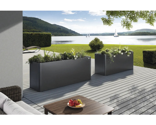 Zwei graue Pflanzkästen auf einer Terrasse mit Seeblick