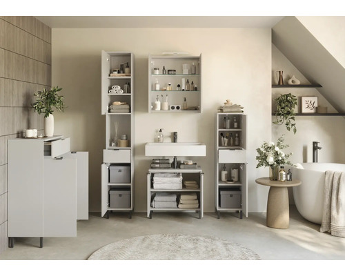 Badezimmer mit Waschtisch, Spiegelschrank und Hochschränken für Badezimmerutensilien und Handtücher.