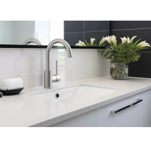 Modernes Badezimmer mit Waschbecken, Armatur, Spiegel und Blumen