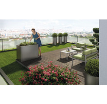 Terrasse mit Gartenmöbeln, Pflanzgefäßen und Frau, die Pflanzen pflegt
