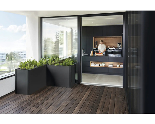 Balkon mit Kräutern in Pflanzkästen und Blick in eine Küche