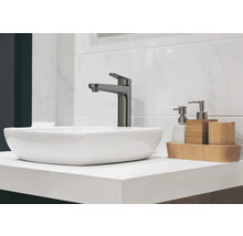 Waschbecken mit Armatur und Badaccessoires auf einer Ablage