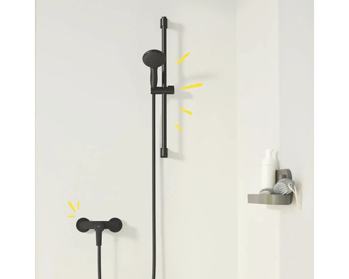 Schwarze Duschgarnitur mit Brausestange und Ablage im Badezimmer.