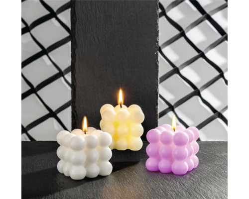 Drei Würfelkerzen mit Bubble-Design in unterschiedlichen Farben stehen auf einer dunklen Oberfläche.