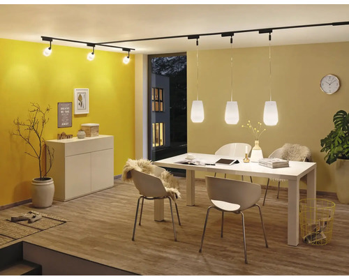 Esszimmer mit Esstisch, Stühlen und Beleuchtungssystem