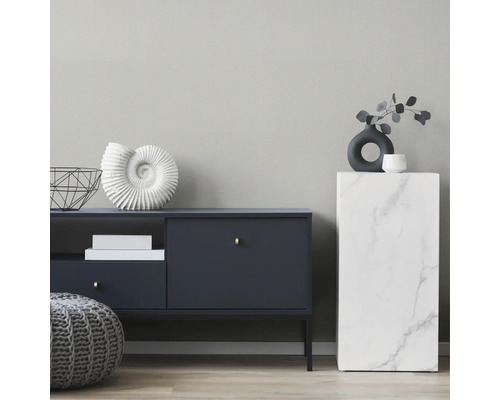 Einrichtungsbeispiel mit Kommode, Marmorsockel und Dekorationsgegenständen in einem hellen Raum.