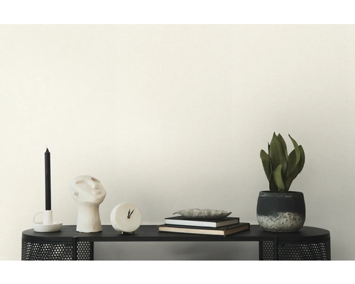 Dekoration mit Kerze, Skulptur, Uhr, Büchern und Zimmerpflanze auf einem schwarzen Regal