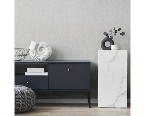 Einrichtungsszene mit Kommode, Beistelltisch und Dekoration vor einer Tapete mit dezenter Struktur.