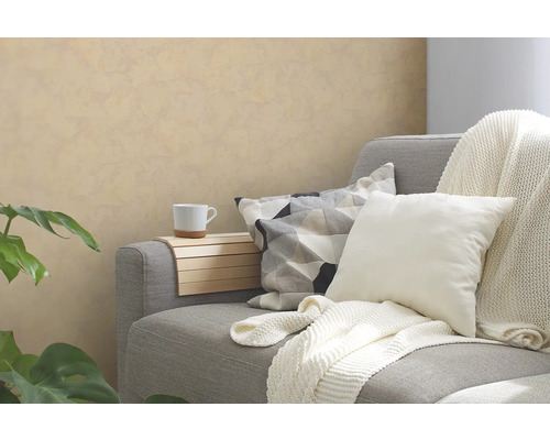 Graues Sofa mit Kissen, Decke, Armlehnentablett und Tasse in einem Wohnraum.