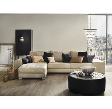 Wohnzimmer mit Ecksofa, Ottoman, Couchtisch und Dekorationsgegenständen.