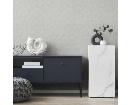 Wohnzimmer mit gemusterter Tapete, Kommode und Dekorationen.