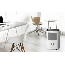 Szene eines Arbeitszimmers mit einem Luftentfeuchter, einem Schreibtisch, zwei Stühlen und einem Beistelltisch.