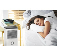 Szene mit einem Luftentfeuchter neben einem Bett mit einer schlafenden Frau.