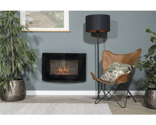 Wohnzimmer mit Elektrokamin, Stehlampe, Sessel und Zimmerpflanzen für eine gemütliche Atmosphäre