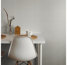 Szene mit weißem Tisch, Stuhl, Tasse, Holzdekoration und Glasvase.