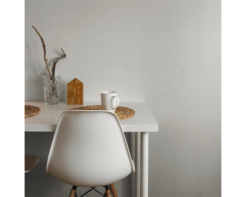 Szene mit weißem Tisch, Stuhl, Tasse, Holzdekoration und Glasvase.