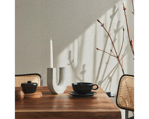 Gedeckter Esstisch mit Dekoration und Stühlen im hellen Raum.