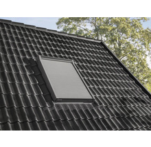 Dachfenster mit geschlossenem Rollladen in einem Ziegeldach