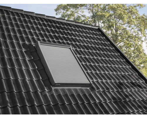 Dachfenster mit geschlossenem Rollladen in einem Ziegeldach