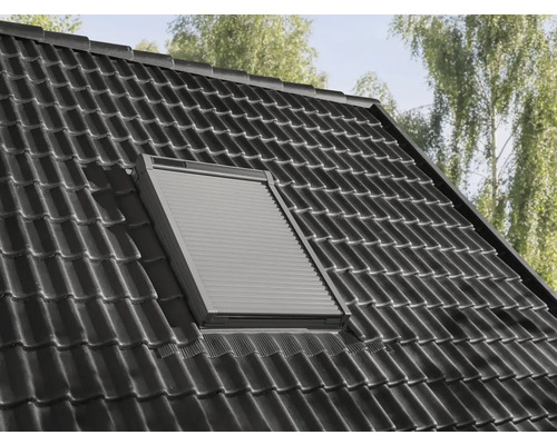 Dachfenster mit geschlossenem Rollladen auf einem Ziegeldach