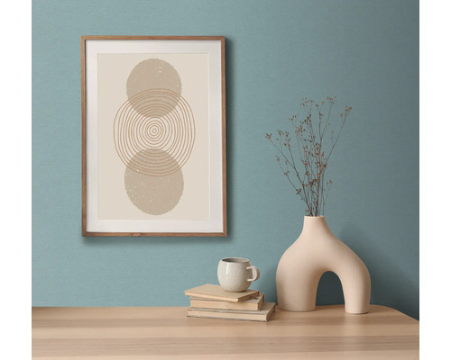 Dekoratives gerahmtes Wandbild mit abstraktem geometrischem Design auf einem Tisch mit Vase, Tasse und Büchern