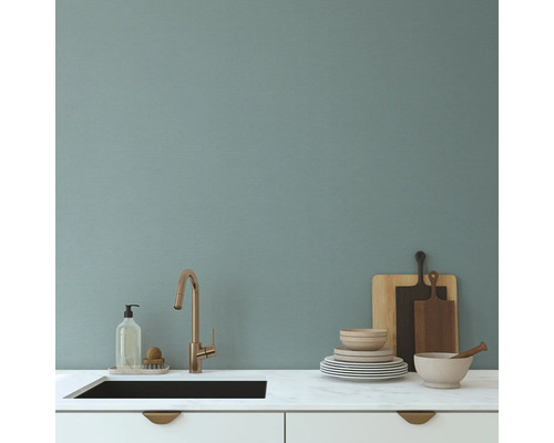 Küchenspüle mit Armatur, Spülmittel, Geschirr und Schneidebrettern auf einer Arbeitsfläche