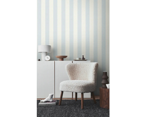 Wohnzimmer mit gestreifter Tapete und einem Sessel mit Holzbeinen