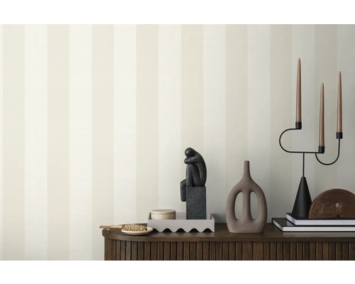 Dekoratives Interieur mit Tapete, Skulptur und Kerzenständer auf einem Sideboard.