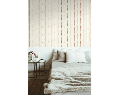 Schlafzimmer mit Bett vor Tapete mit Streifenmuster